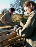 Tom O'Kane and Richard Fletcher cutting out joints on a green oak timber framing course at the Felin Uchaf Education Centre, Aberdaron, Gwynedd, North Wales
