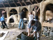 Plastering the cob pillars on the Earthouse at the Felin Uchaf Centre, North wales