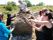 Volunteers building a cob wall